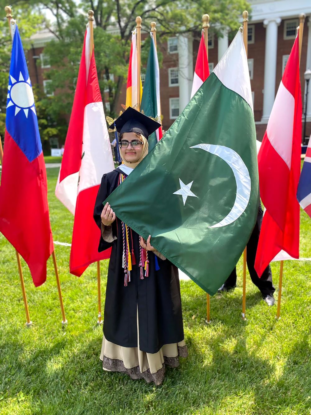 Maryam at graduation, holding the Pakistani flag